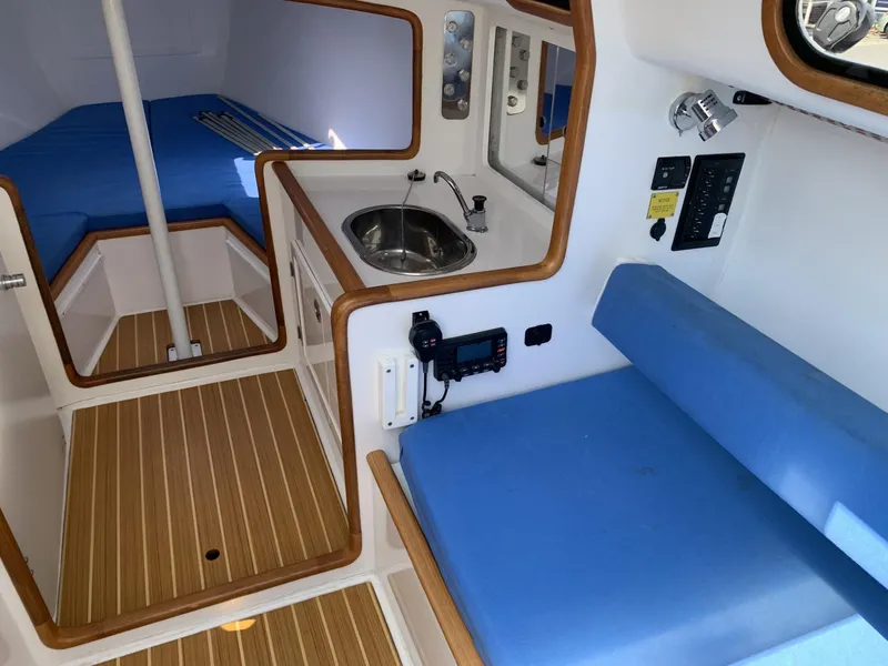 Slide: The Image of Interior of 2017 Sparkman & Stephens 30 sailboat with blue seating and compact kitchenette. - 16