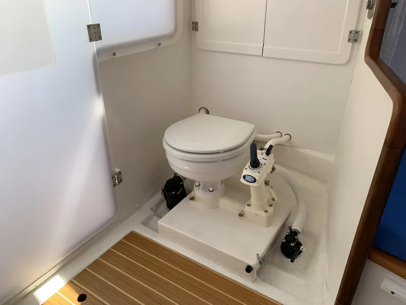 Slide: The Image of 2017 Sparkman & Stephens 30 yacht bathroom with marine toilet and wooden floor mat. - 18