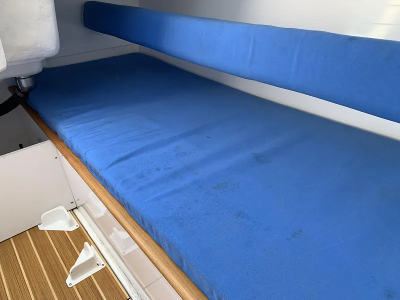 Slide: The Image of Interior cabin of 2017 Sparkman & Stephens 30 with blue cushions and wooden flooring. - 19