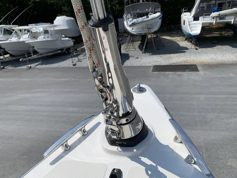 Slide: The Image of Bow of a 2017 Sparkman & Stephens 30 sailboat with mast detail, docked among other boats. - 7