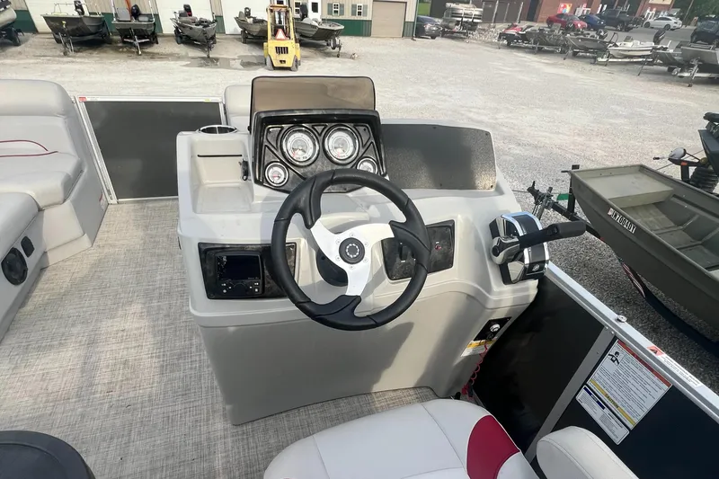 Slide: The Image of 2022 SunCatcher Select 18C boat dashboard with steering wheel and control panel. - 9
