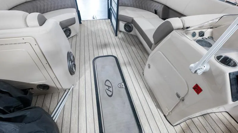 Slide: The Image of Interior of 2021 Harris SUNLINER 230 SLDH pontoon boat with beige seating and wood flooring. - 15