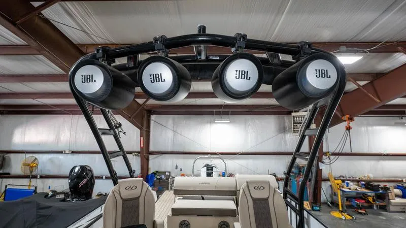 Slide: The Image of 2021 Harris SUNLINER 230 SLDH boat with JBL speakers in a workshop. - 16