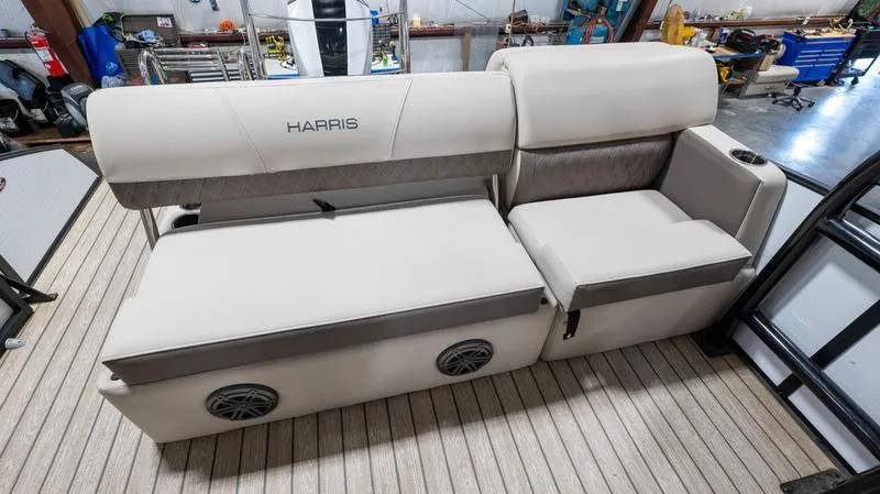 Slide: The Image of 2021 Harris SUNLINER 230 SLDH boat interior with beige seating and built-in speakers. - 19
