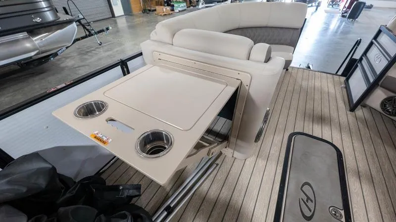 Slide: The Image of 2021 Harris SUNLINER 230 SLDH boat interior with foldable table and cup holders. - 25