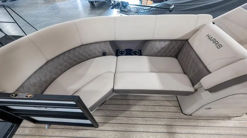 Slide: The Image of 2021 Harris SUNLINER 230 SLDH boat interior with beige seating and cup holders. - 7