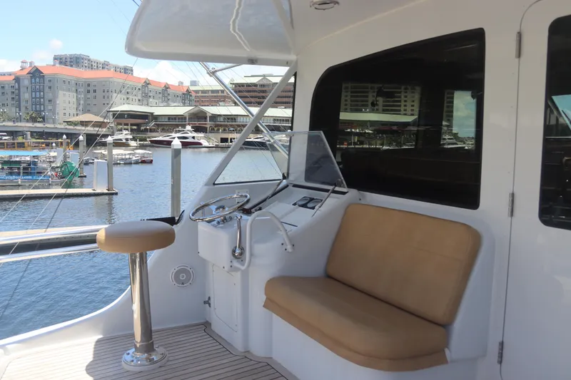 Slide: The Image of Hatteras 70 Convertible 2003 yacht helm station with seating at marina. - 13