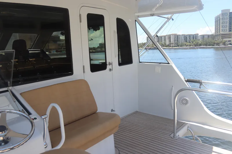 Slide: The Image of 2003 Hatteras 70 Convertible yacht deck with seating and waterfront view. - 14