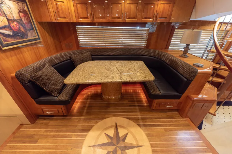 Slide: The Image of Luxurious dining area in 2003 Hatteras 70 Convertible yacht with granite table and wood flooring. - 21