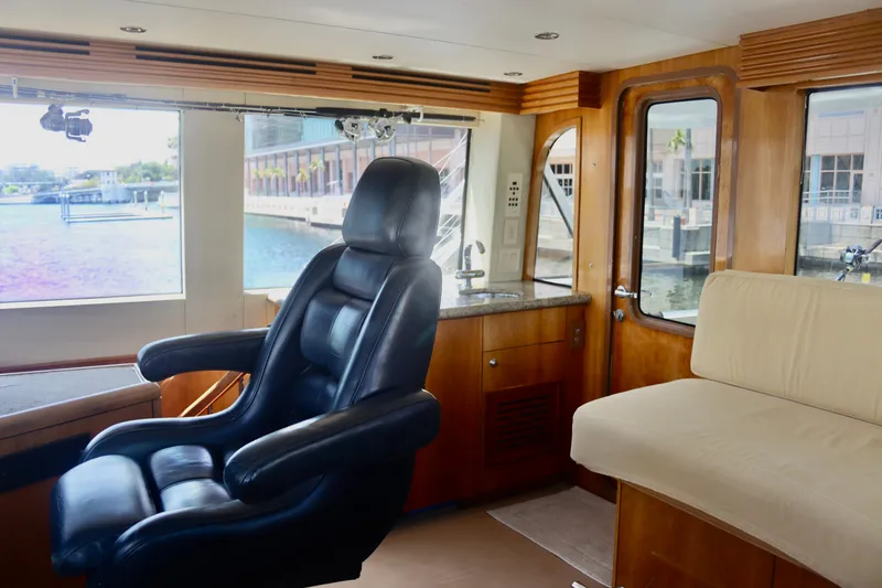 Slide: The Image of Interior of 2003 Hatteras 70 Convertible yacht with leather captain's chair and waterfront view. - 24