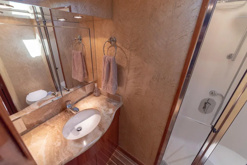 Slide: The Image of Luxurious bathroom in 2003 Hatteras 70 Convertible yacht with marble countertop and glass shower. - 37