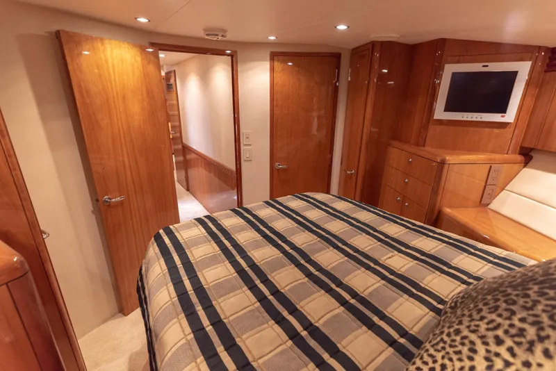 Slide: The Image of Luxurious bedroom interior of 2003 Hatteras 70 Convertible yacht with wood finishes and TV. - 39