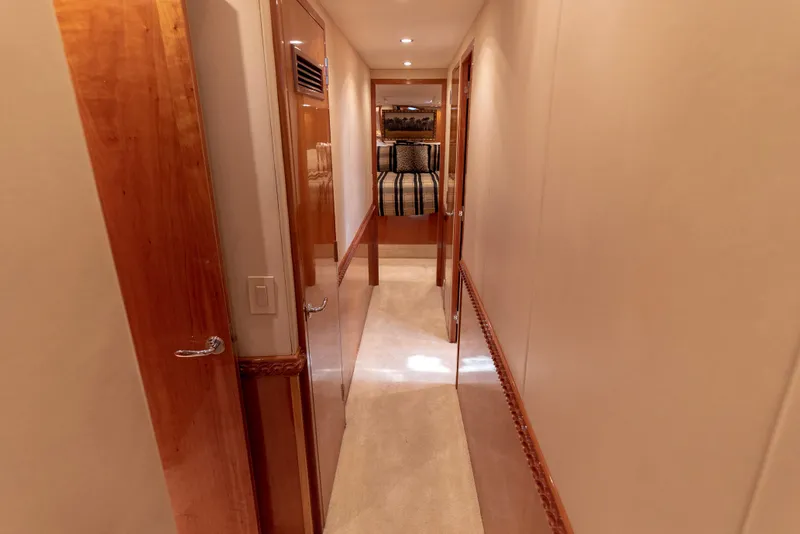 Slide: The Image of Hallway inside 2003 Hatteras 70 Convertible yacht with wooden doors and carpeted floor. - 48