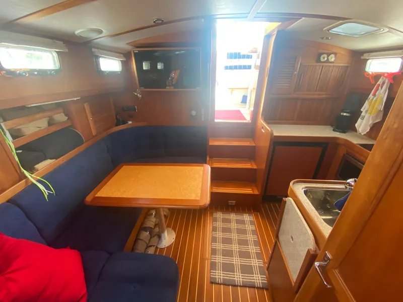 Slide: The Image of Interior of 2003 Sabre 36 sailboat with wooden finishes and cozy seating area. - 10