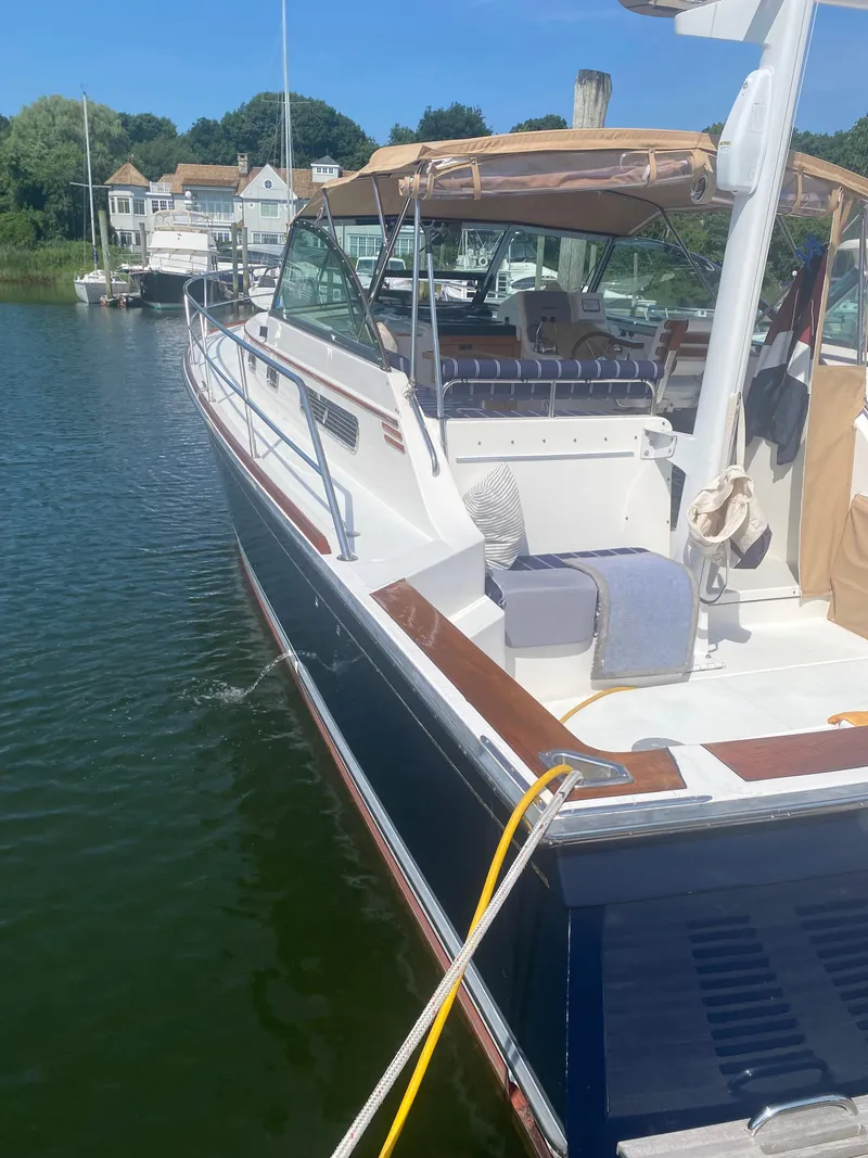 Slide: The Image of 2003 Sabre 36 boat docked in a marina with scenic background. - 3