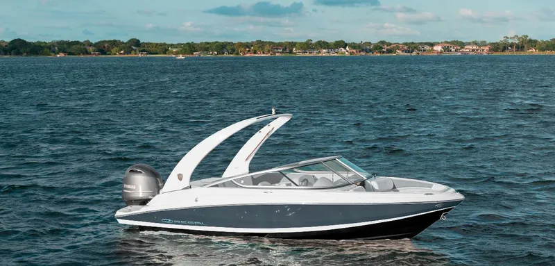The Image of 2024 Regal 21 OBX boat cruising on a lake with scenic shoreline. - 0