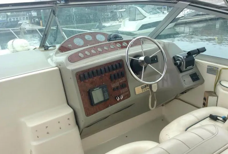 Slide: The Image of 1997 Maxum 3200 SCR boat dashboard with steering wheel and control panel. - 12