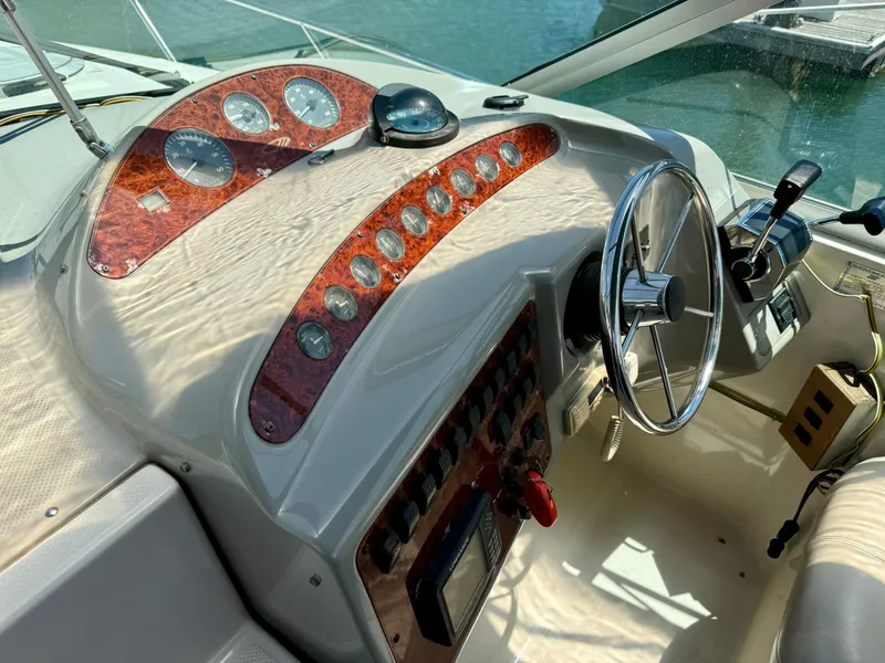 Slide: The Image of 1997 Maxum 3200 SCR boat dashboard with steering wheel and control panel. - 13