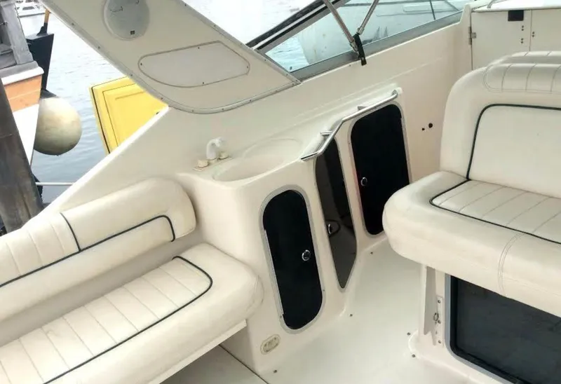 Slide: The Image of Interior of a 1997 Maxum 3200 SCR boat with white seating and storage compartments. - 15