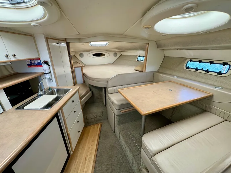 Slide: The Image of 1997 Maxum 3200 SCR cabin interior with kitchenette, dining area, and sleeping quarters. - 4