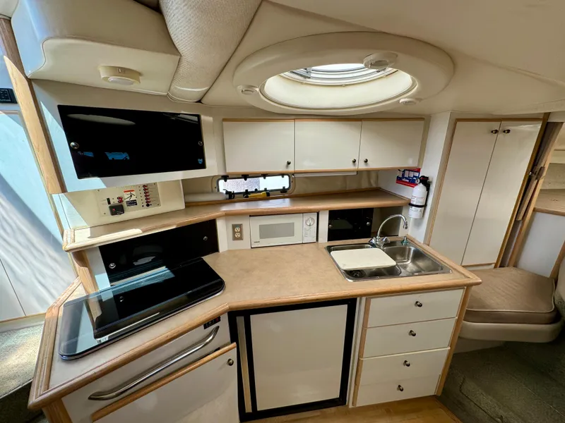 Slide: The Image of Interior of 1997 Maxum 3200 SCR yacht with modern kitchen amenities. - 5