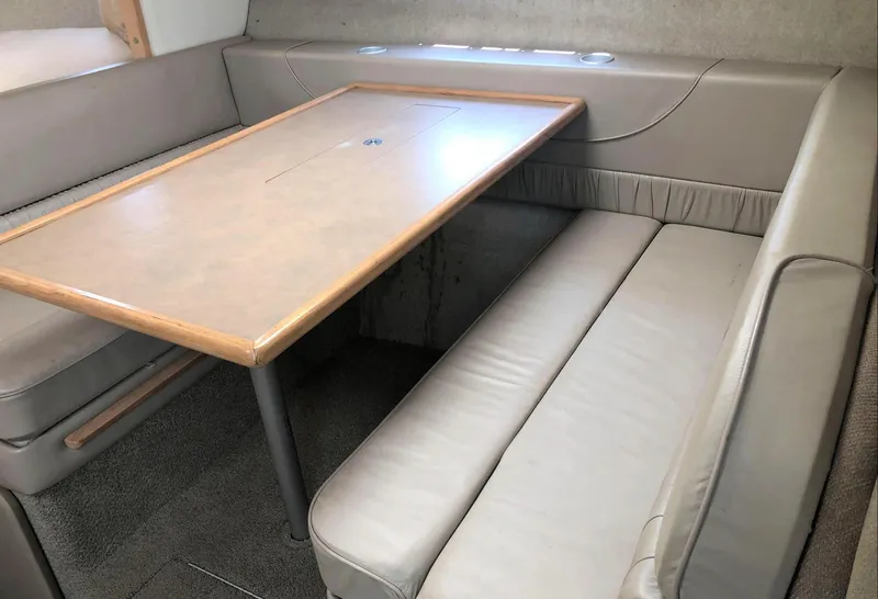 Slide: The Image of 1997 Maxum 3200 SCR interior with beige seating and wooden table. - 6