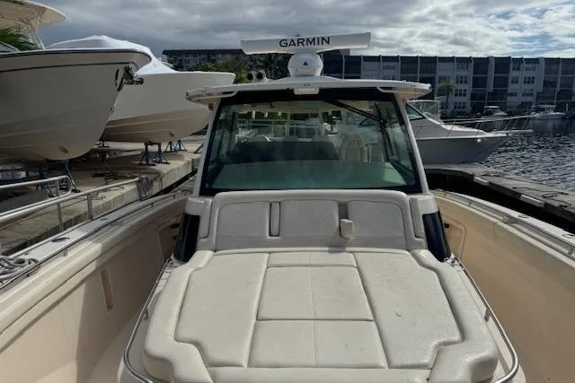 Slide: The Image of 2024 Grady-White Canyon 456 boat docked, featuring Garmin equipment, with other boats in the background. - 11