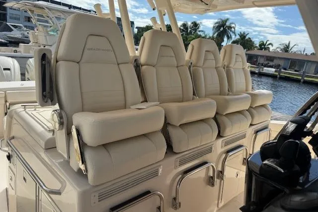 Slide: The Image of Luxurious seating on 2024 Grady-White Canyon 456 boat, featuring plush, cream-colored captain's chairs. - 16