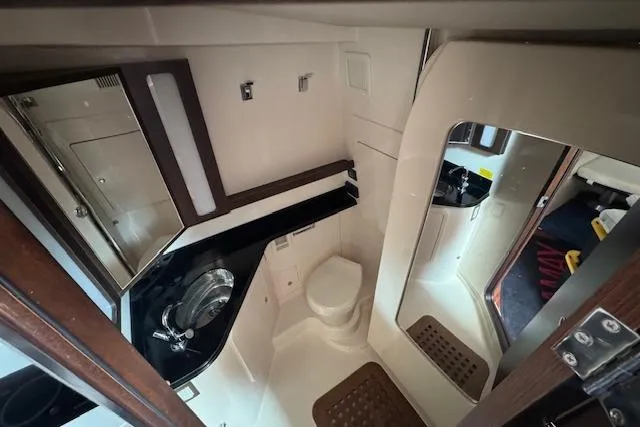 Slide: The Image of 2024 Grady-White Canyon 456 boat interior bathroom with sink, toilet, and mirror. - 26