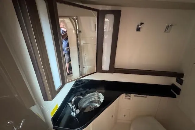 Slide: The Image of 2024 Grady-White Canyon 456 boat interior, featuring sleek bathroom with modern sink and mirror. - 27