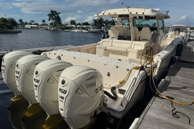 Slide: The Image of 2024 Grady-White Canyon 456 boat docked, featuring four Yamaha 450 V8 engines. - 3