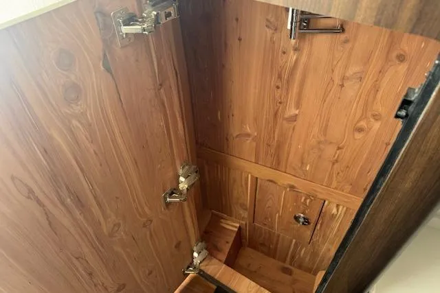 Slide: The Image of Wooden cabinet interior with metal hinges in 2024 Grady-White Canyon 456 boat. - 39