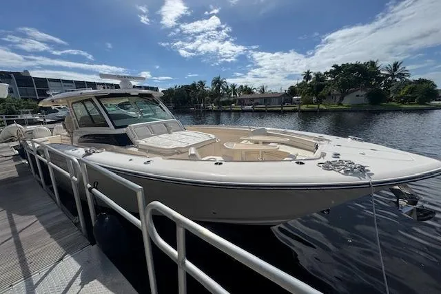 Slide: The Image of 2024 Grady-White Canyon 456 boat docked by a scenic waterfront. - 4