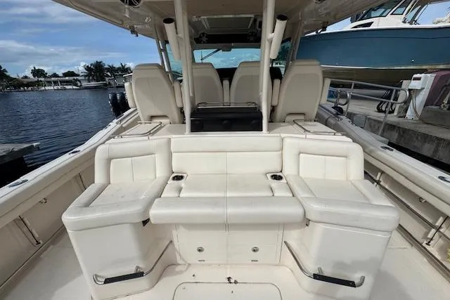 Slide: The Image of 2024 Grady-White Canyon 456 boat interior with seating, docked by the water. - 8