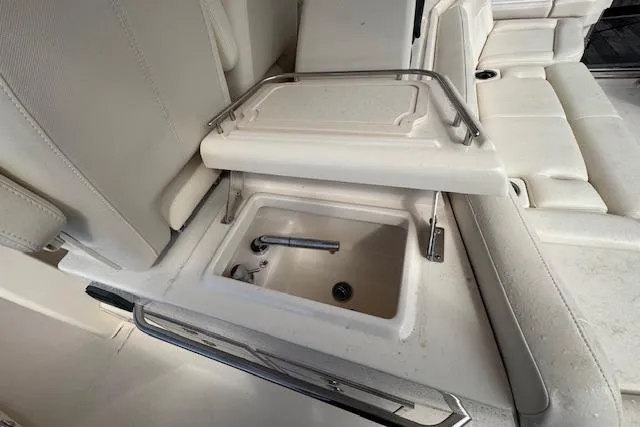 Slide: The Image of 2024 Grady-White Canyon 456 boat interior with built-in sink and seating area. - 9