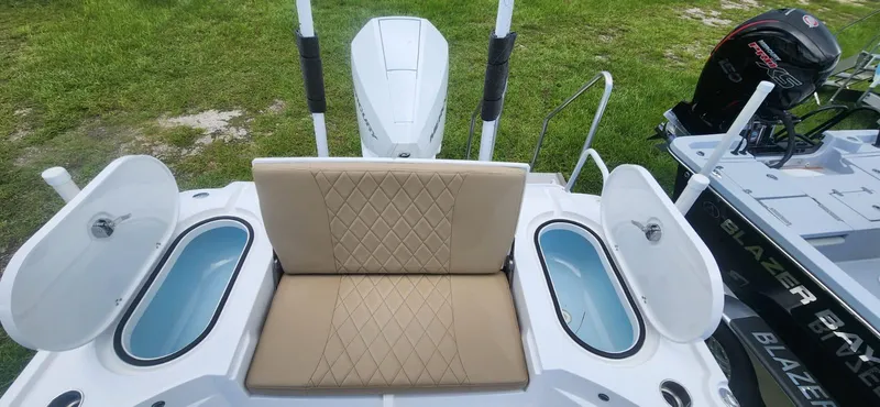 Slide: The Image of Blazer Bay 2440 2025 model boat with tan seating and open storage compartments. - 10