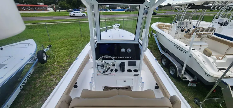 Slide: The Image of 2025 Blazer Bay 2440 boat interior with steering console and seating. - 4