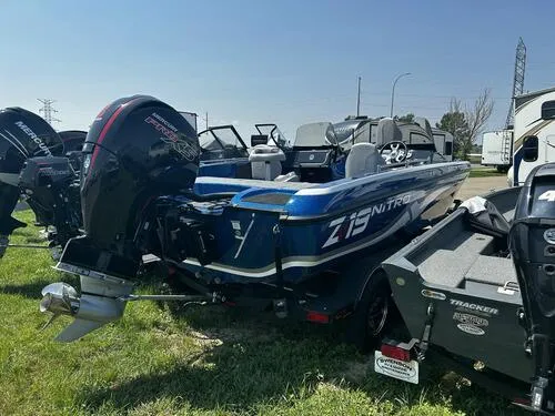 Slide: The Image of 2024 Nitro ZV19 Sport boat with powerful outboard motor, parked on grass. - 3