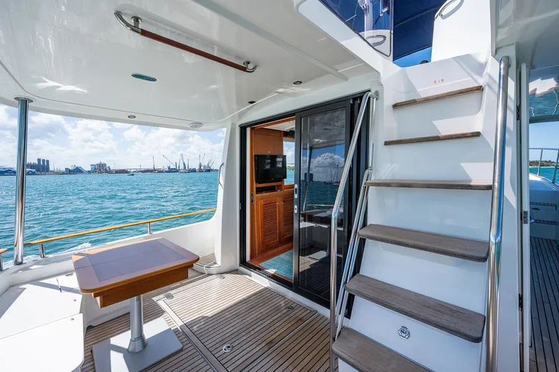 Slide: The Image of 2018 Beneteau Swift Trawler 44 helm station with ocean view and blue canopy. - 17