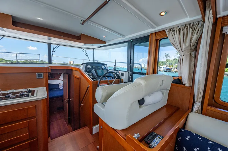 Slide: The Image of 2018 Beneteau Swift Trawler 44 helm station with navigation equipment and steering wheel. - 24
