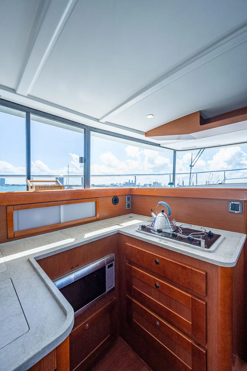 Slide: The Image of 2018 Beneteau Swift Trawler 44 interior helm station with panoramic windows. - 25