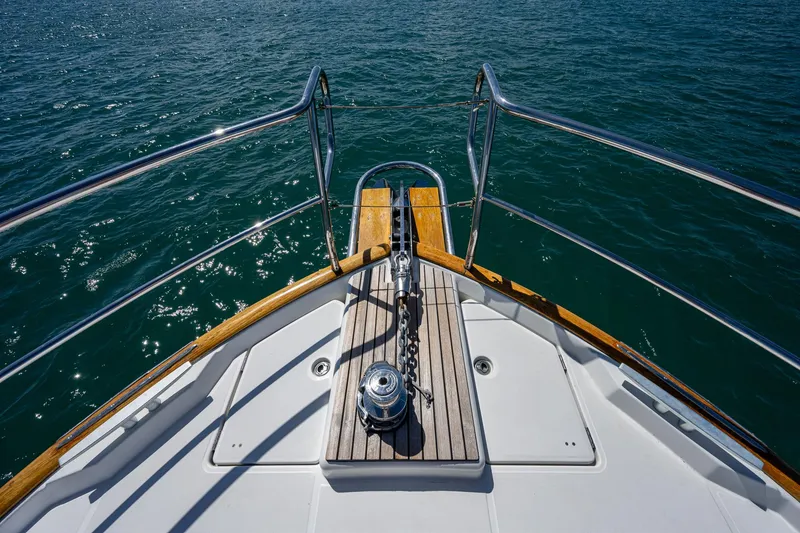 Slide: The Image of 2018 Beneteau Swift Trawler 44 bow view on open water with city skyline. - 5