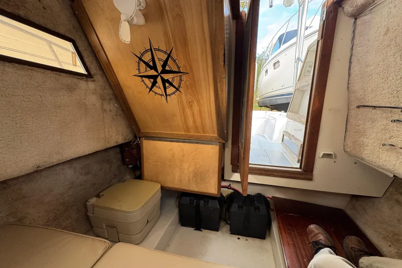 Slide: The Image of Interior of 1981 Mako 233 Walk Around boat with compass design on wooden panel. - 11