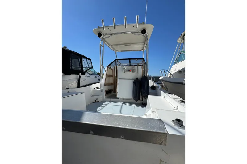 Slide: The Image of 1981 Mako 233 Walk Around boat, open deck view under clear blue sky. - 12