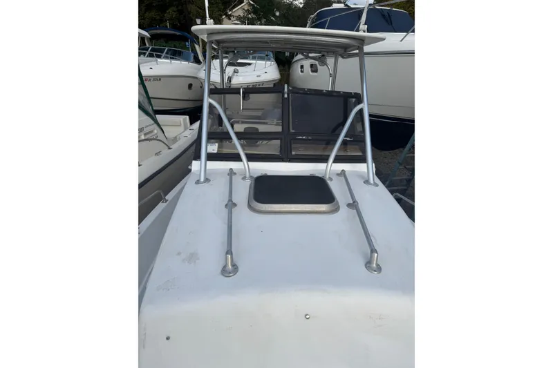 Slide: The Image of 1981 Mako 233 Walk Around boat with a white deck and metal railings. - 18