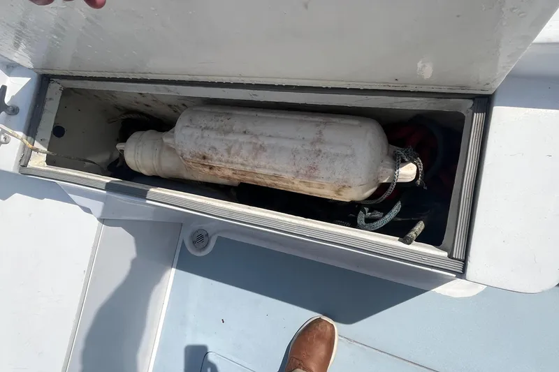 Slide: The Image of Storage compartment of a 1981 Mako 236 boat with a white fender inside. - 19