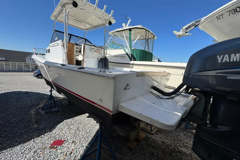 Slide: The Image of 1981 Mako 233 Walk Around boat on stands, featuring Yamaha outboard motor. - 2