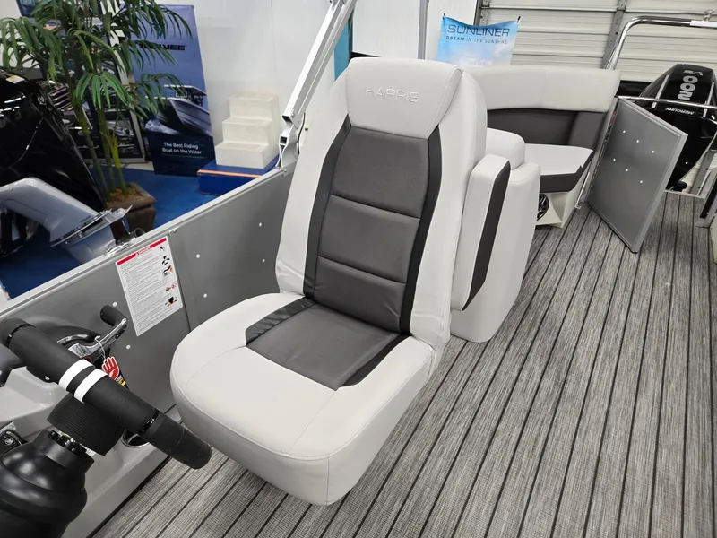 Slide: The Image of 2024 Harris Cruiser 210 boat interior with gray captain's chair and striped flooring. - 11