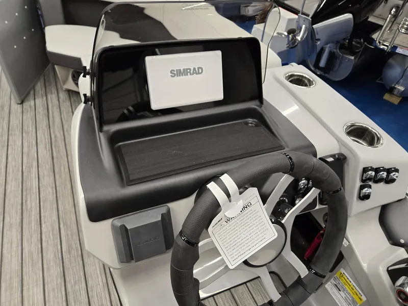 Slide: The Image of 2024 Harris Cruiser 210 boat dashboard with Simrad display and steering wheel. - 12