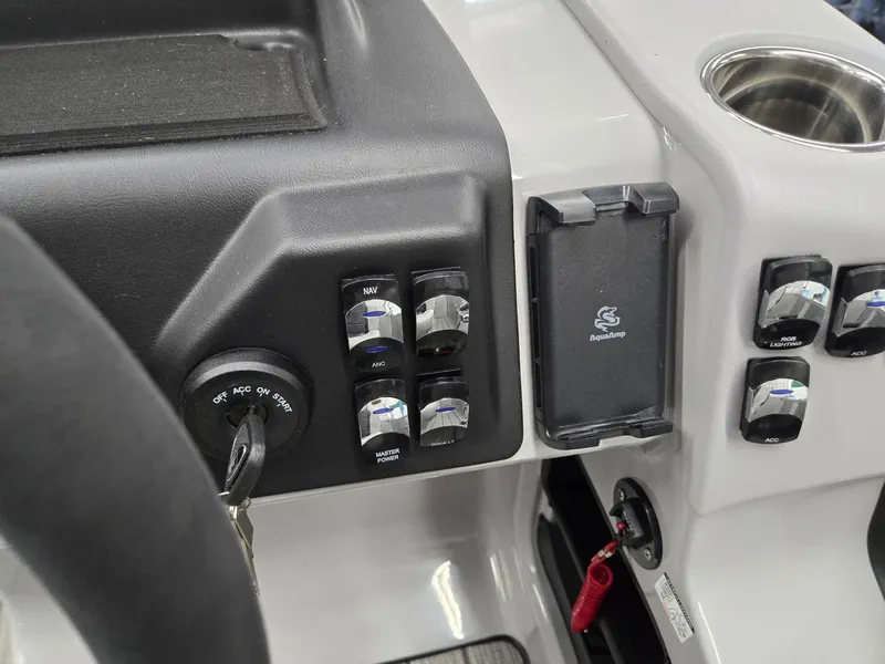 Slide: The Image of Control panel of 2024 Harris Cruiser 210 boat with ignition, switches, and cup holder. - 15